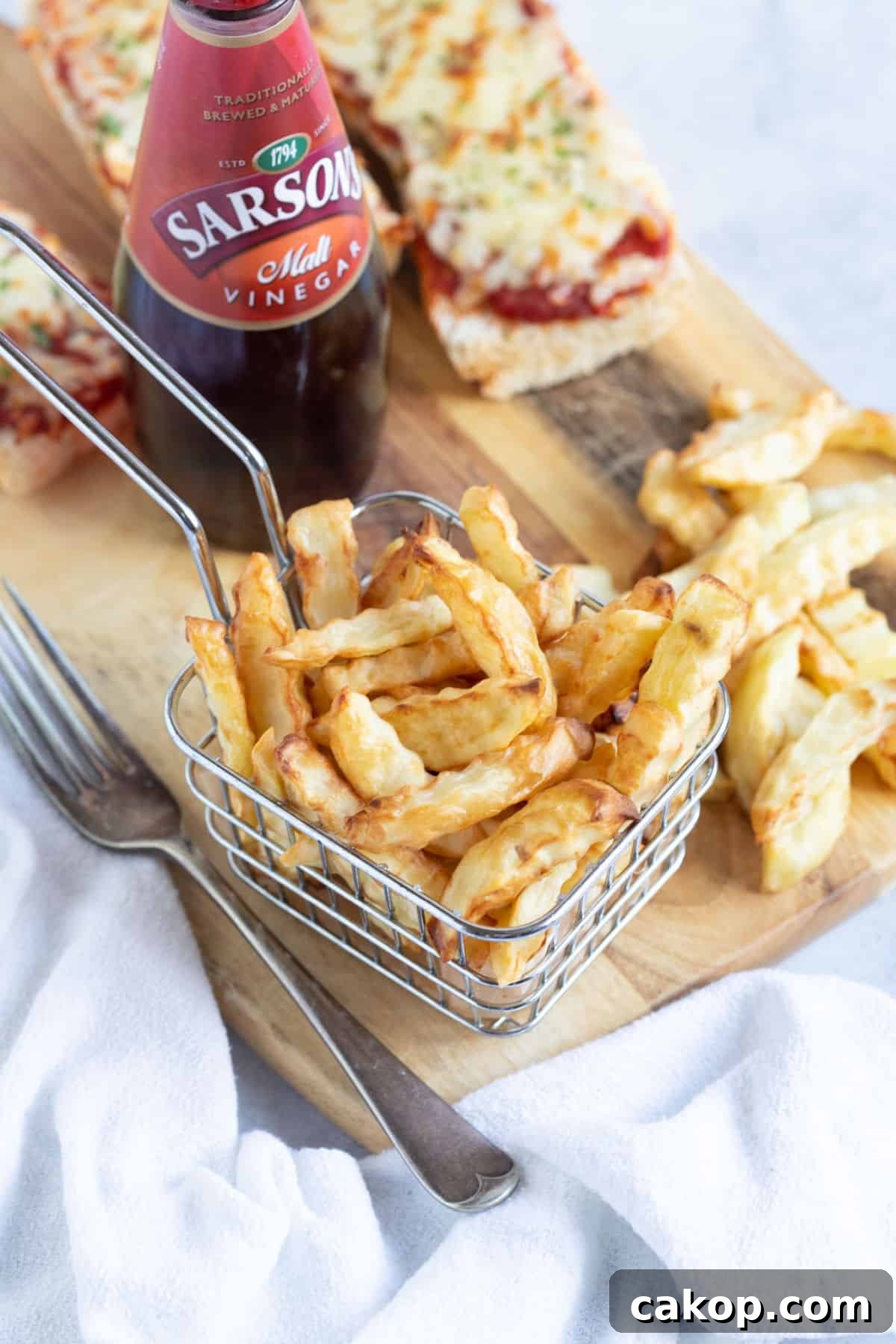 A basket of air fryer chips with baguette pizzas.