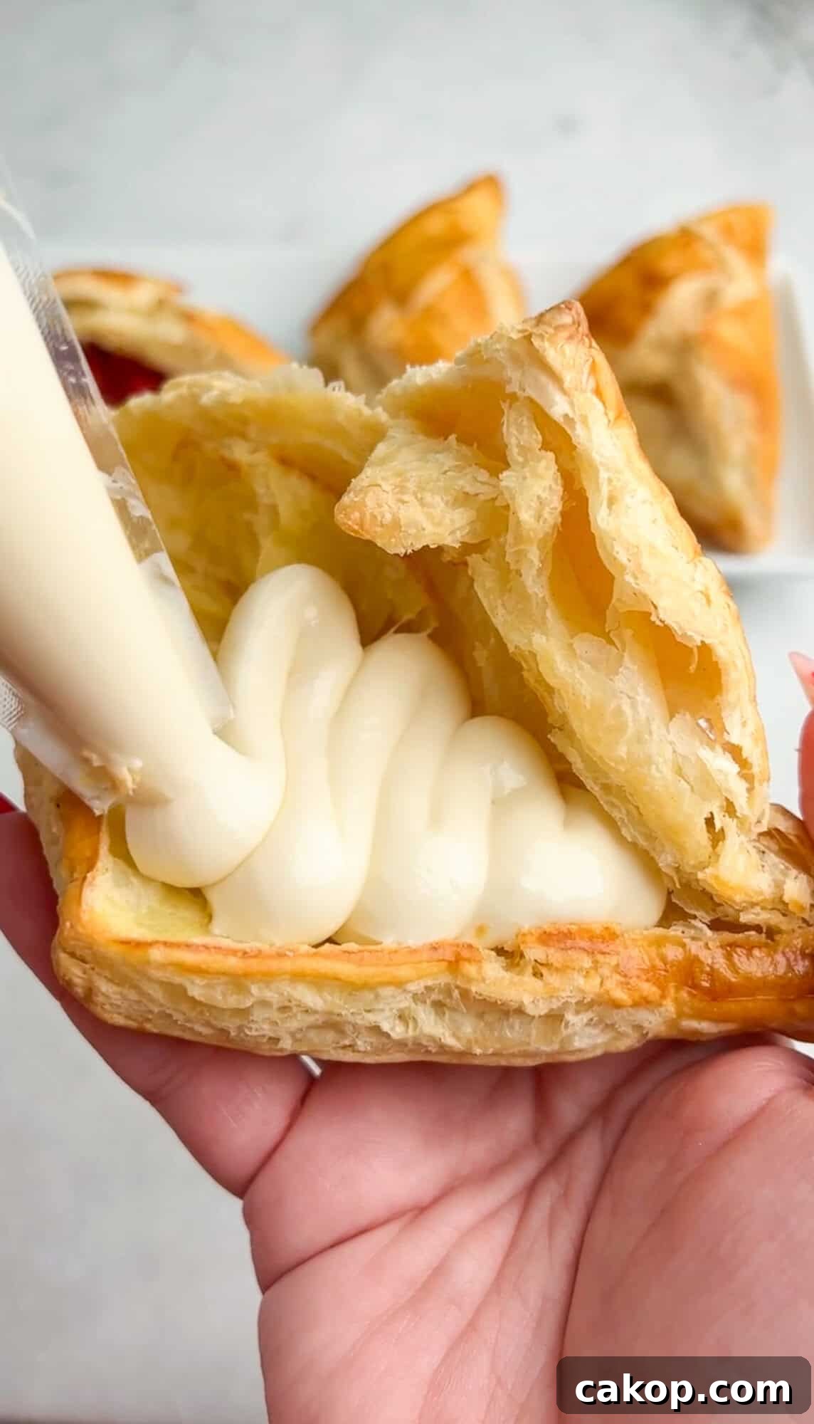 Strawberry Cheesecake Turnover Recipe — Flaky Pastry with Creamy Filling 10 piping in cheesecake filling into pastry shell