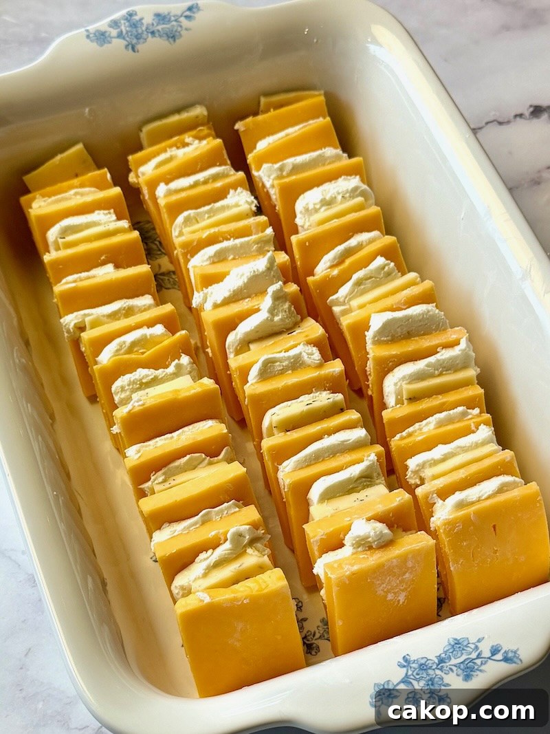 Mediterranean Marinated Cheese Bites for Party Appetizers 8 Cheese layered in a shallow dish.