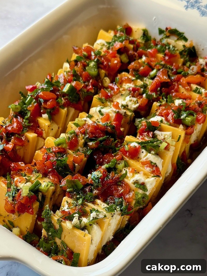 Mediterranean Marinated Cheese Bites for Party Appetizers 9 Marinade poured over the layered cheese.