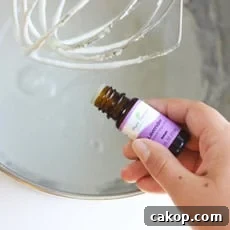 Whipped Gingerbread Body Butter: DIY Recipe for Silky Skin 3 lavender essential oil being added to a kitchenaid mixer of homemade diaper rash cream