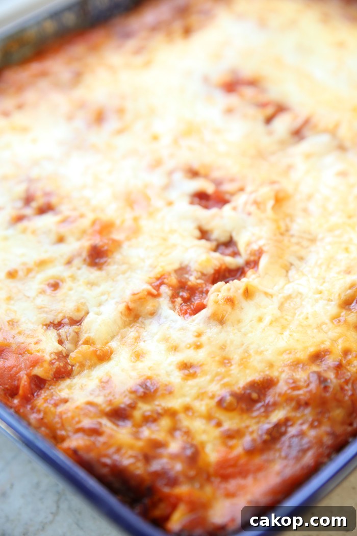 A diagonal placed large rectangular Polish pottery baking dish of fire roasted red pepper lasagna.