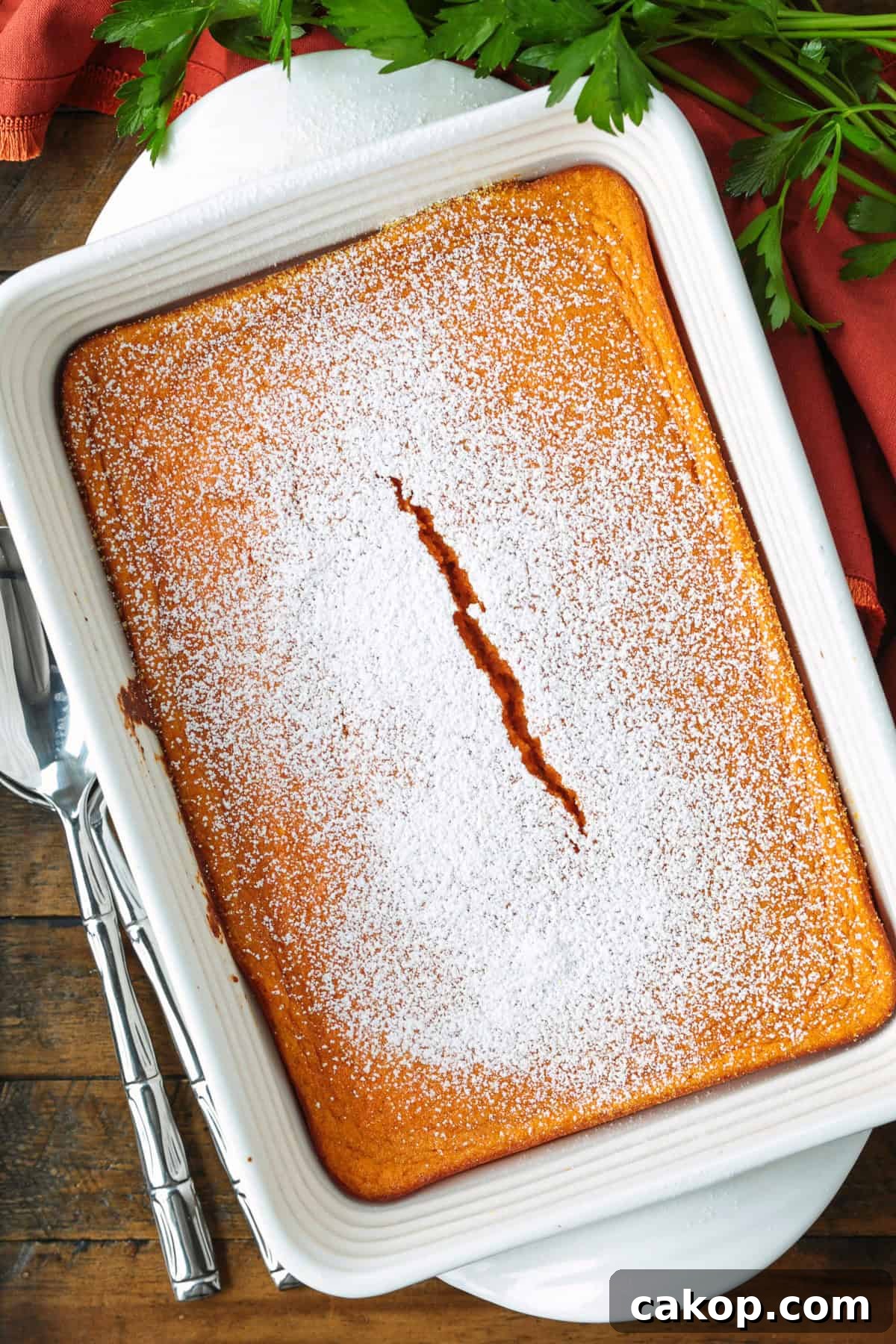 baking dish with baked carrot souffle and spoon on the side