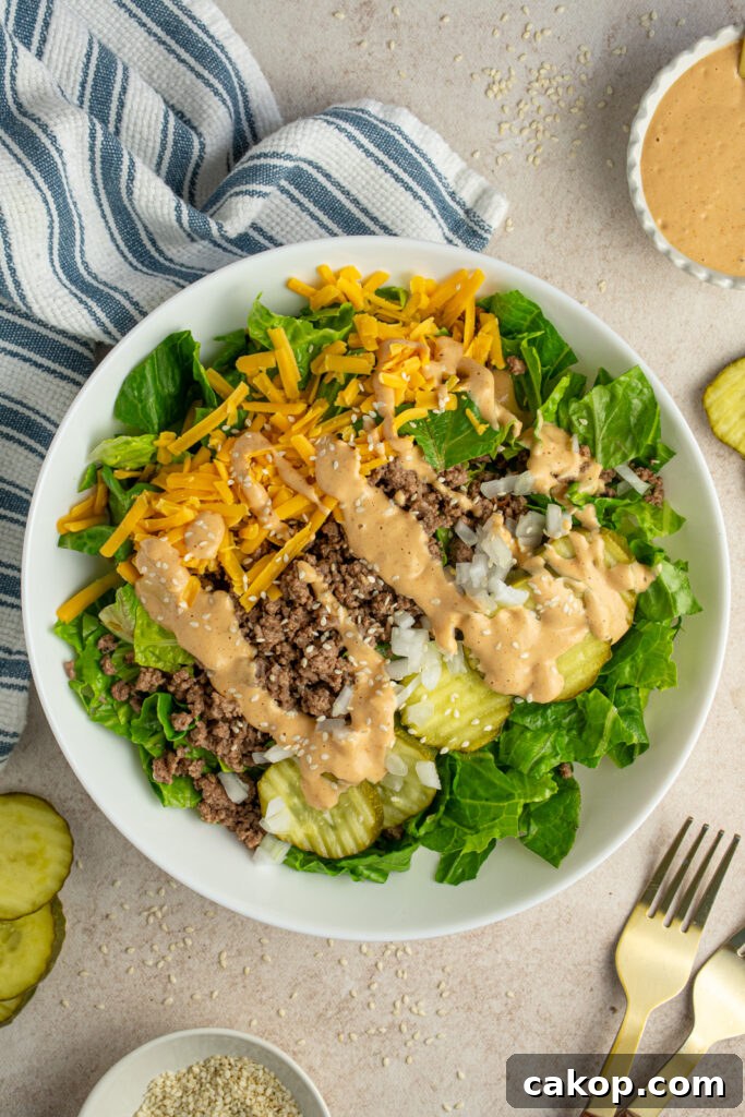 Overhead view of a white bowl with big mac salad with special sauce.