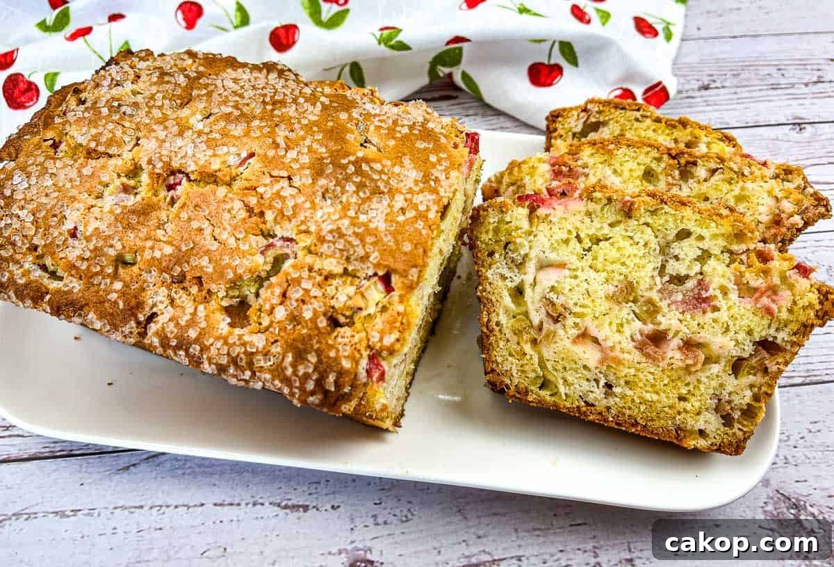 A loaf of Rhubarb Bread with a few slices on a white plate.