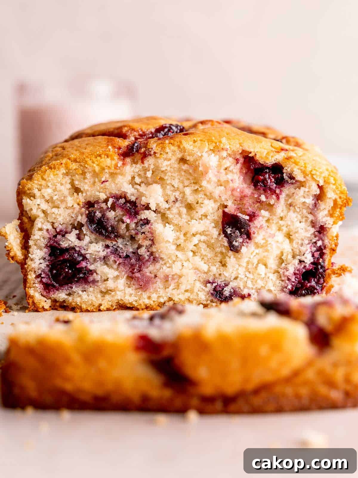 Cherry Loaf Cake Recipe: Moist Homemade Cherry Bread 2 A cherry loaf cake with a slice cut off of the end.