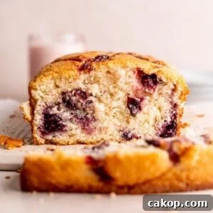 Cherry Loaf Cake Recipe: Moist Homemade Cherry Bread 9 A cherry loaf cake with a slice cut off of the end.