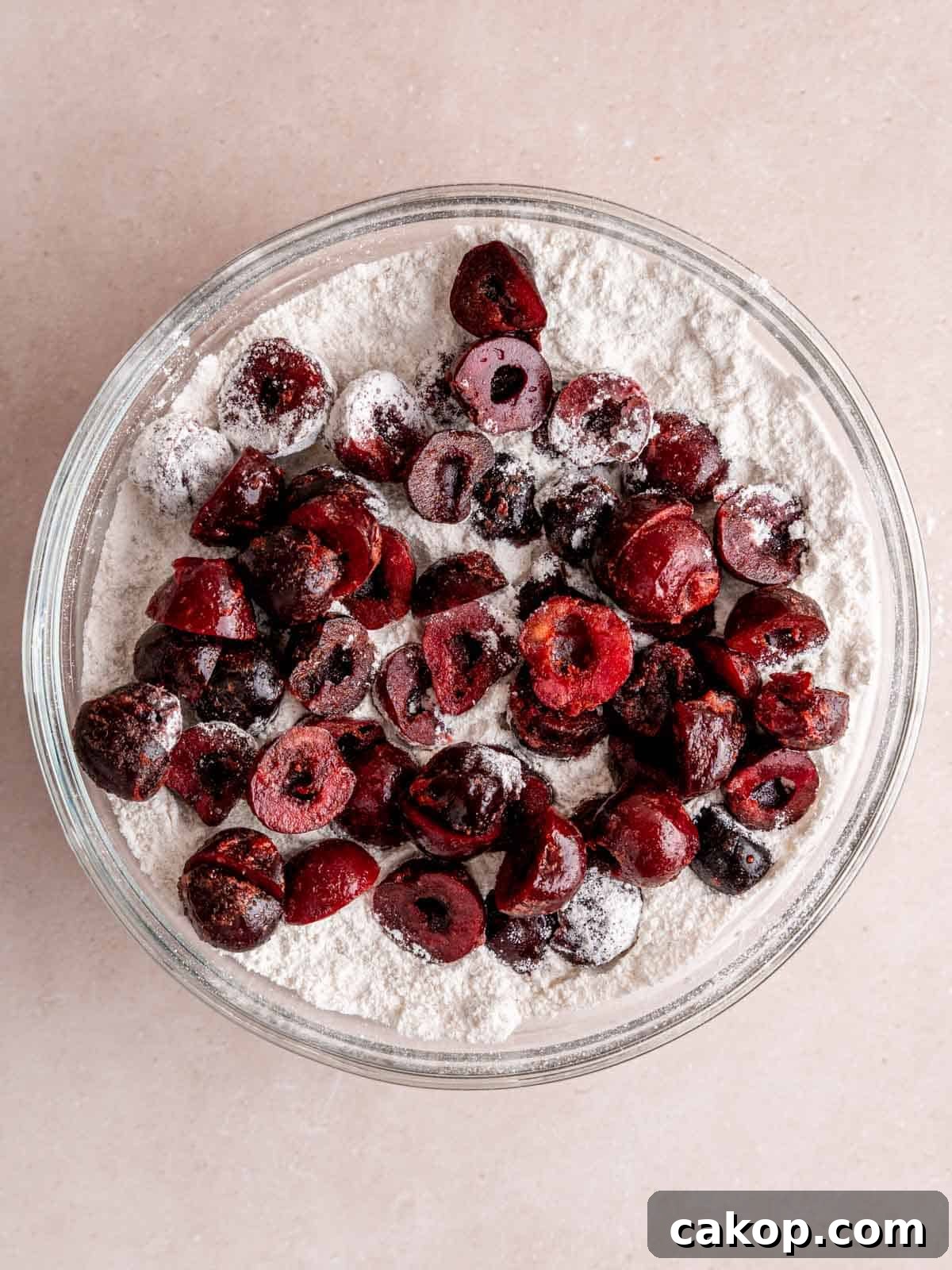 Cherry Loaf Cake Recipe: Moist Homemade Cherry Bread 4 Halved cherries in a bowl of flour mixture.