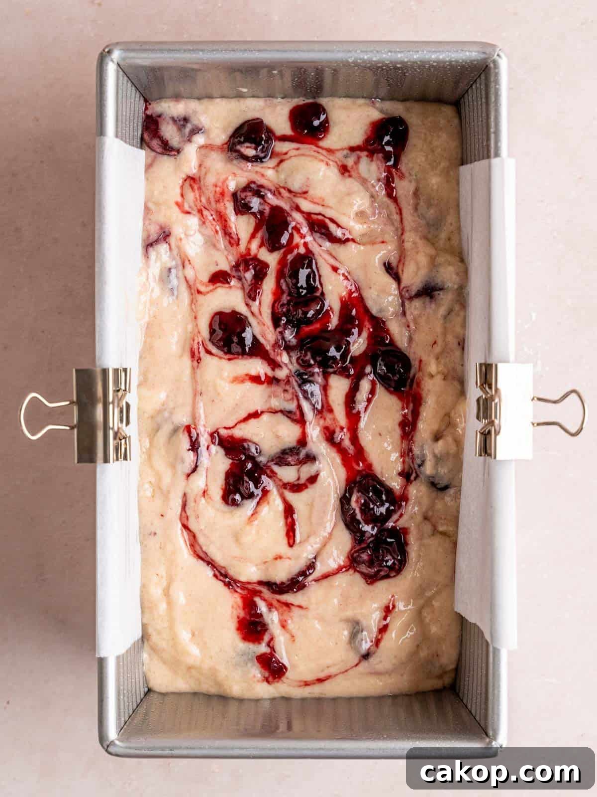 Cherry Loaf Cake Recipe: Moist Homemade Cherry Bread 7 Cherry cake batter in a loaf pan with cherry preserves swirled on top.
