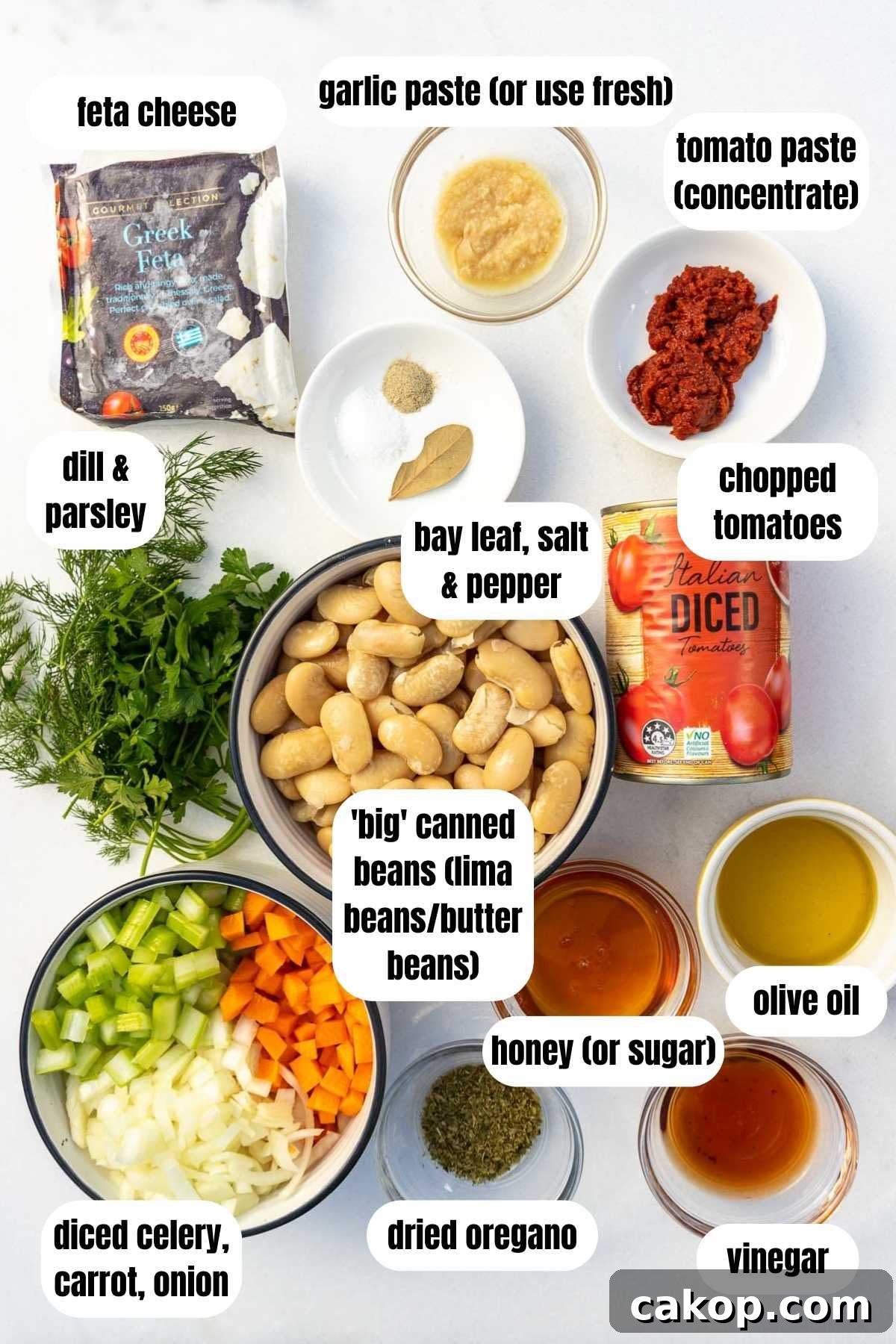 Greek Gigantes Plaki with Canned Giant Beans: Authentic Recipe 3 An overhead view of all the ingredients needed to make quick Greek giant beans including chopped onion, carrot and celery, dried oregano, garlic paste, vinegar, honey, olive oil, canned lima or butter beans, chopped tomatoes, tomato paste, salt, pepper and a bay leaf, feta cheese, and fresh dill and parsley.