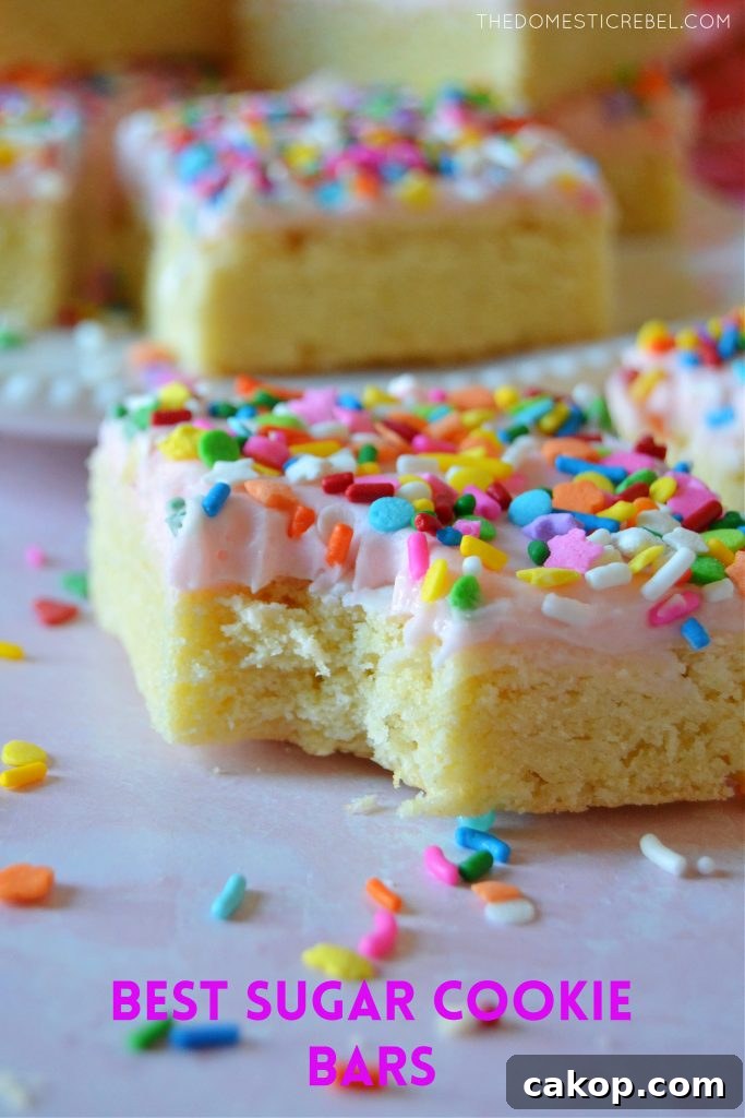 Sprinkle Sugar Cookie Bars Recipe — Soft, Chewy, Crowd-Pleasing 2 Bite missing on a sugar cookie bar with sprinkles