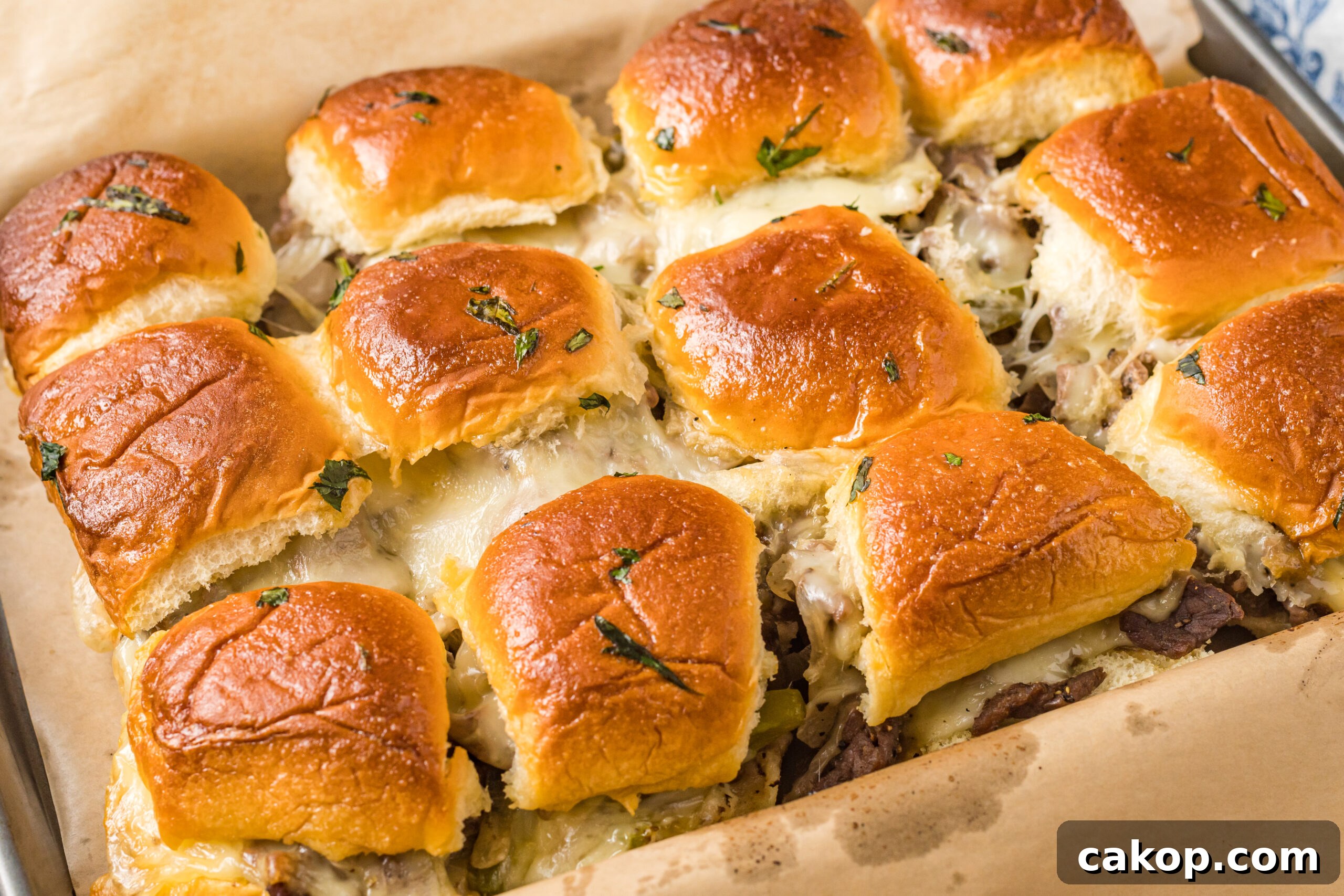 Philly Cheesesteak Sliders Recipe: Savory Mini Sandwiches for Game Day 9 Philly Cheesesteak Sliders on a baking sheet, oozing with melty cheese!