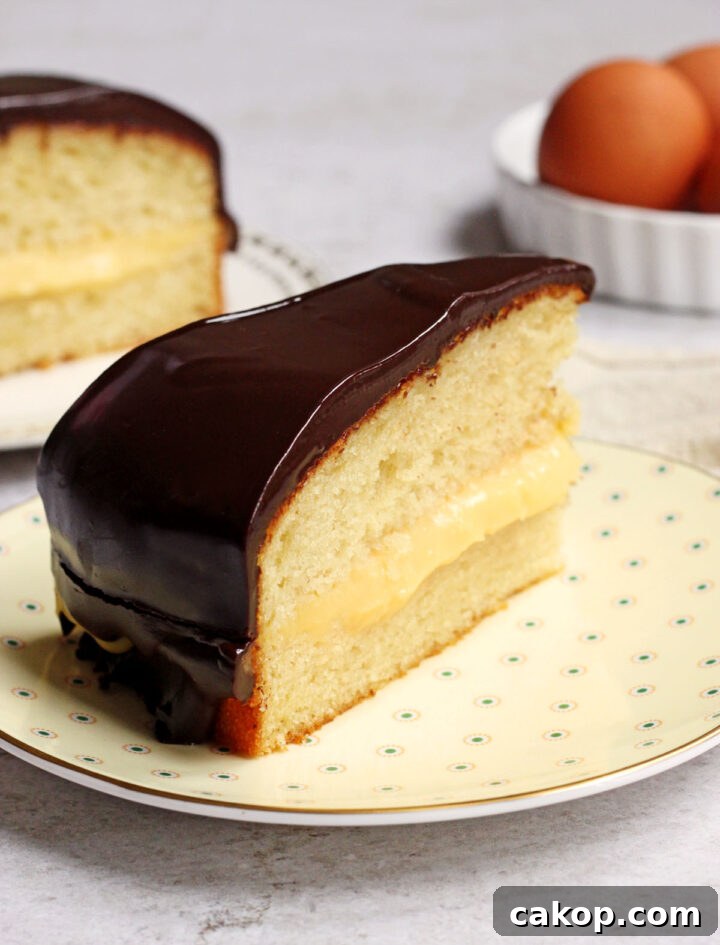 Classic Boston Cream Pie Recipe: Creamy Custard & Chocolate Glaze 7 slice of Boston cream pie on a plate