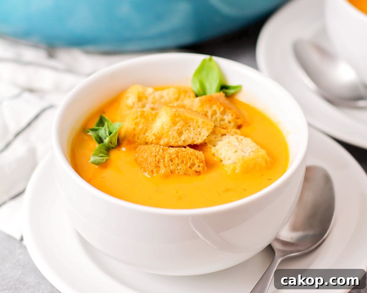 A bowl of roasted tomato soup topped with croutons.