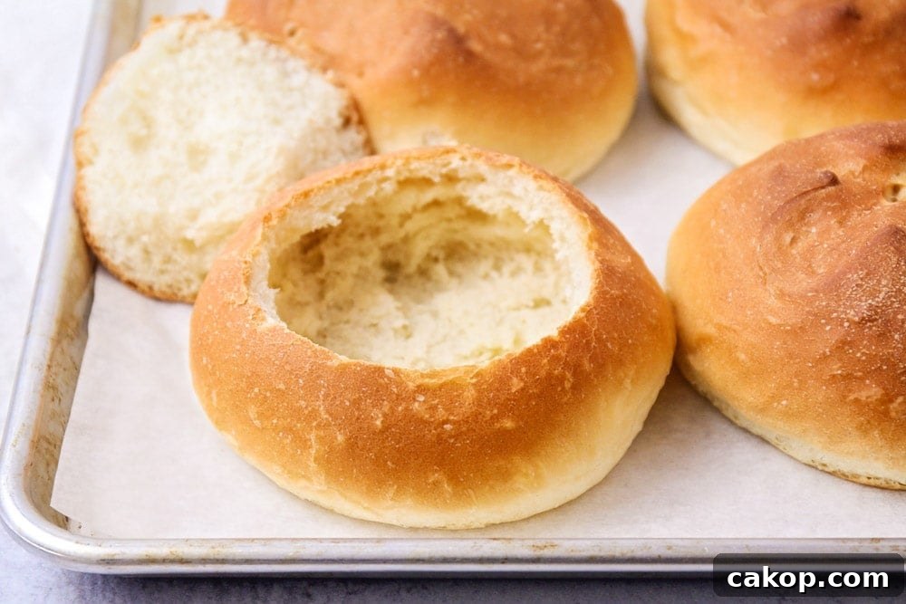 A baking sheet filled with bread bowls.