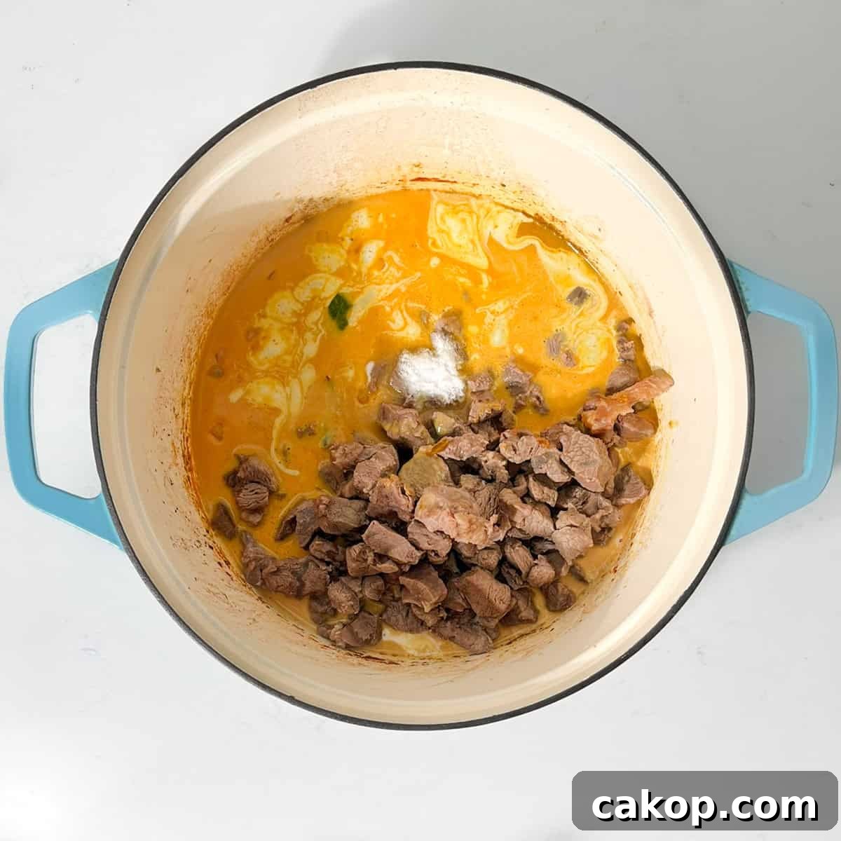 Adding the beef back into the pot for the beef curry with coconut milk.