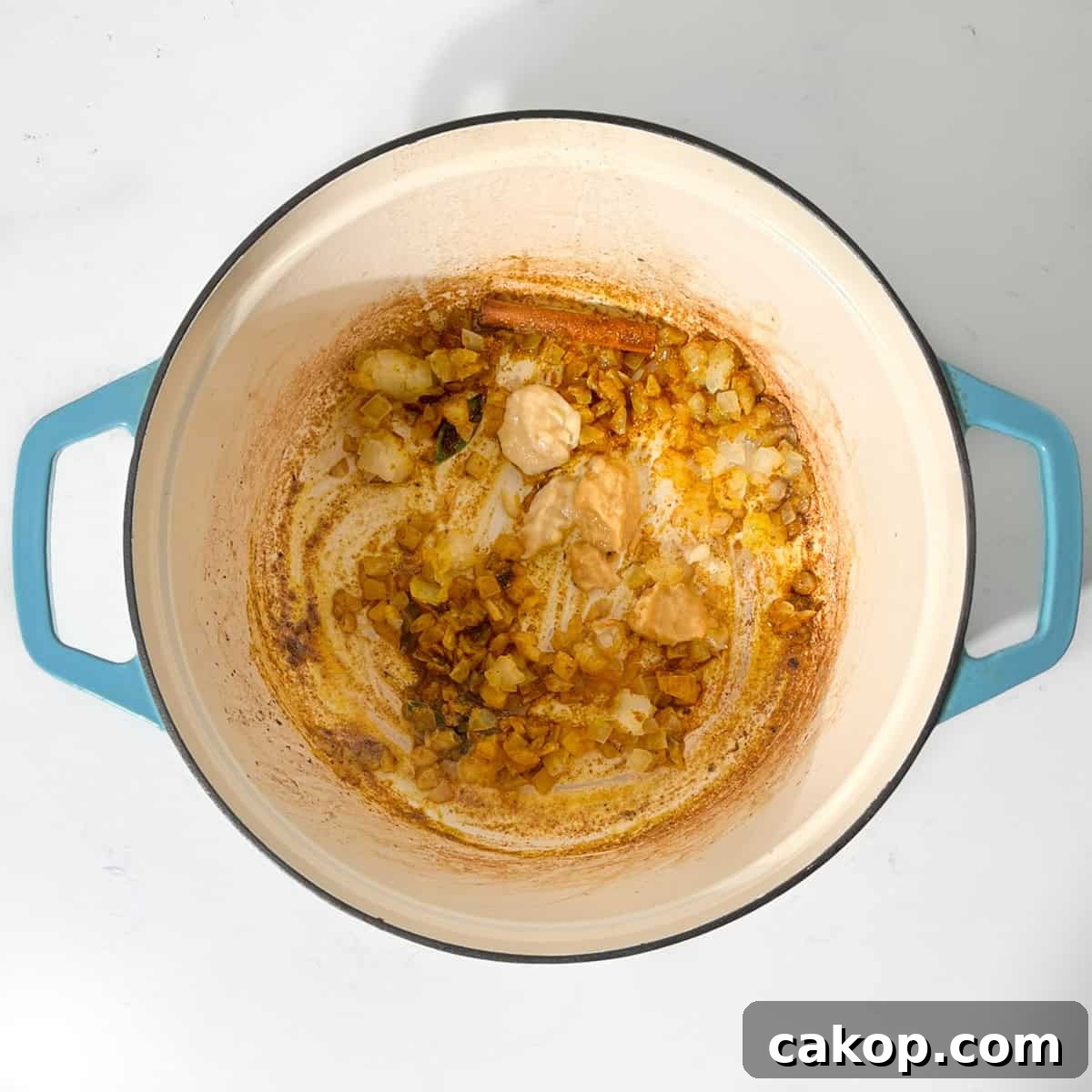Adding garlic and ginger to the fried onions in a large saucepan.