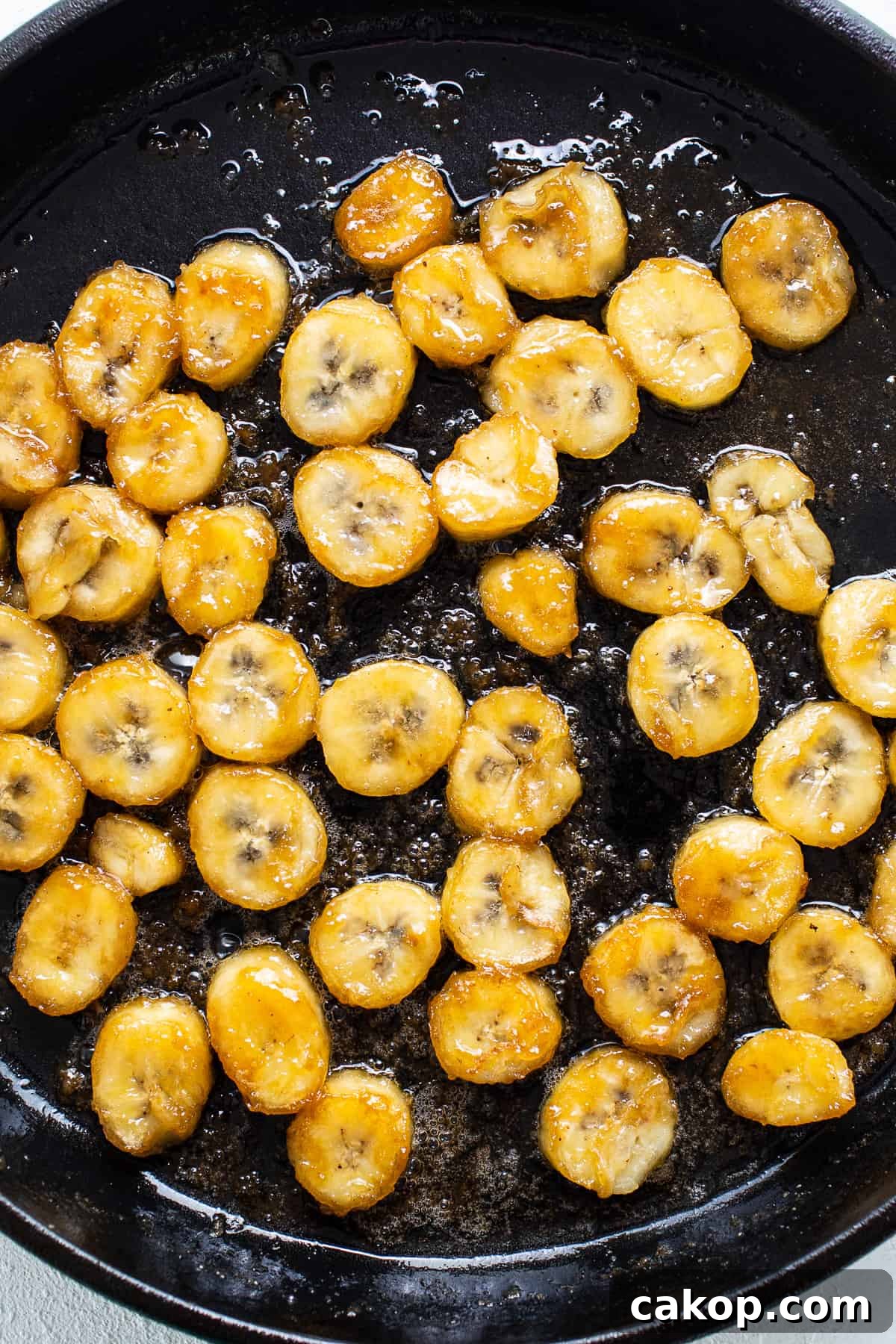 Bananas Foster French Toast Recipe for Brunch or Dessert 5 Sliced bananas are being fried in a skillet.