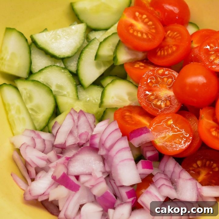 Prepare the vegetables: dice tomatoes and cucumber and thinly slice red onion.