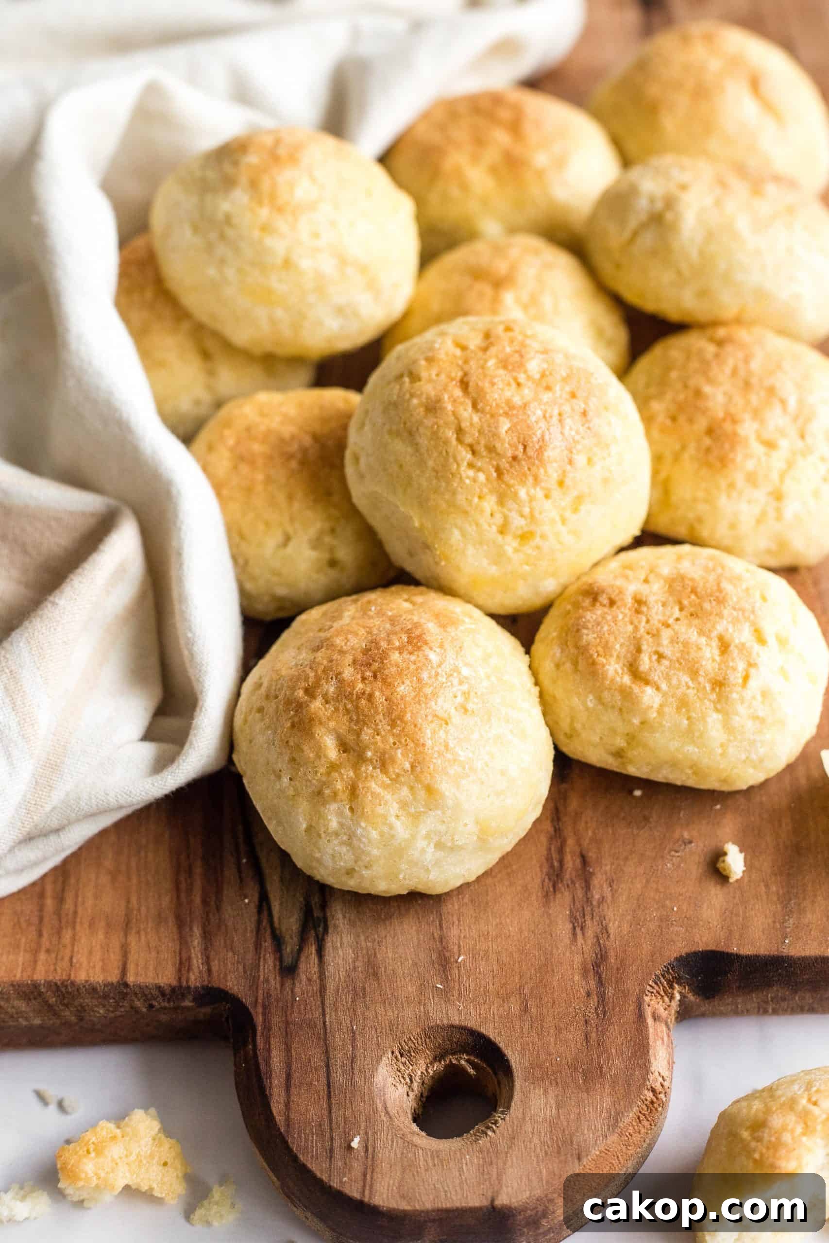 Soft Gluten-Free Dinner Rolls (Dairy-Free) Gluten-free dinner rolls piled on a wooden board.