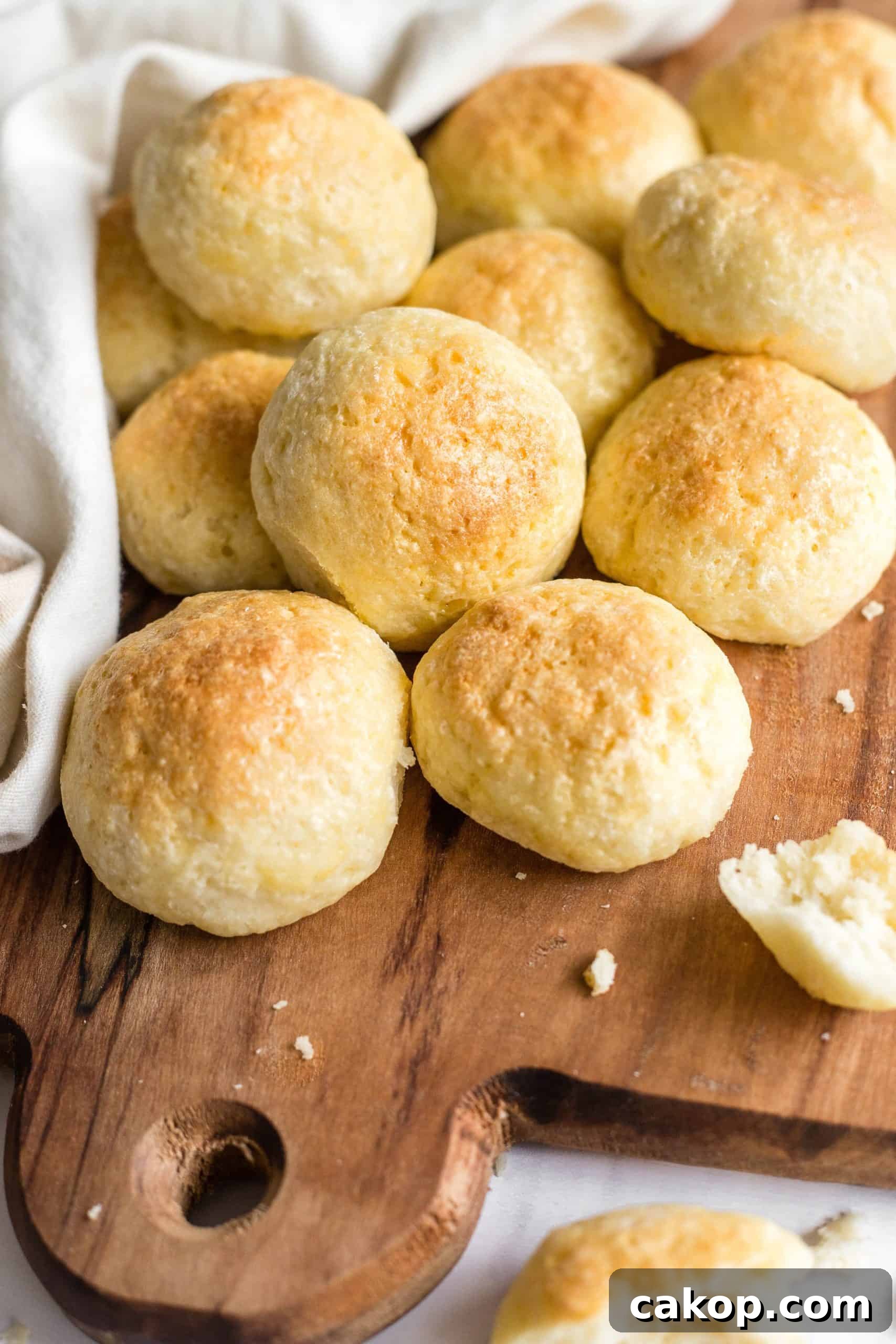 Soft Dinner Rolls (Gluten-Free, Dairy-Free) Gluten-free dinner rolls piled onto a wooden board.