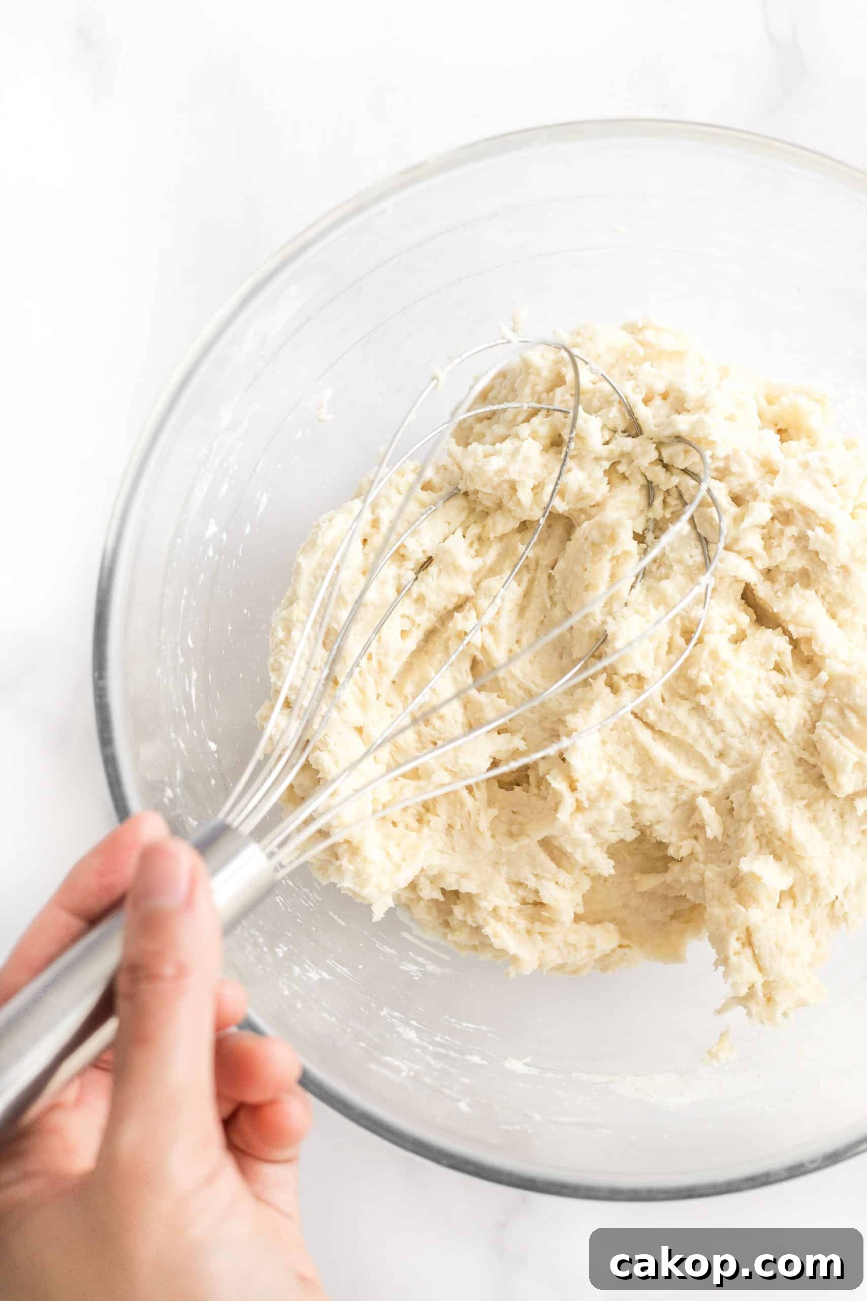 Soft Gluten-Free Dairy-Free Dinner Rolls Mixing bread dough in glass mixing bowl.