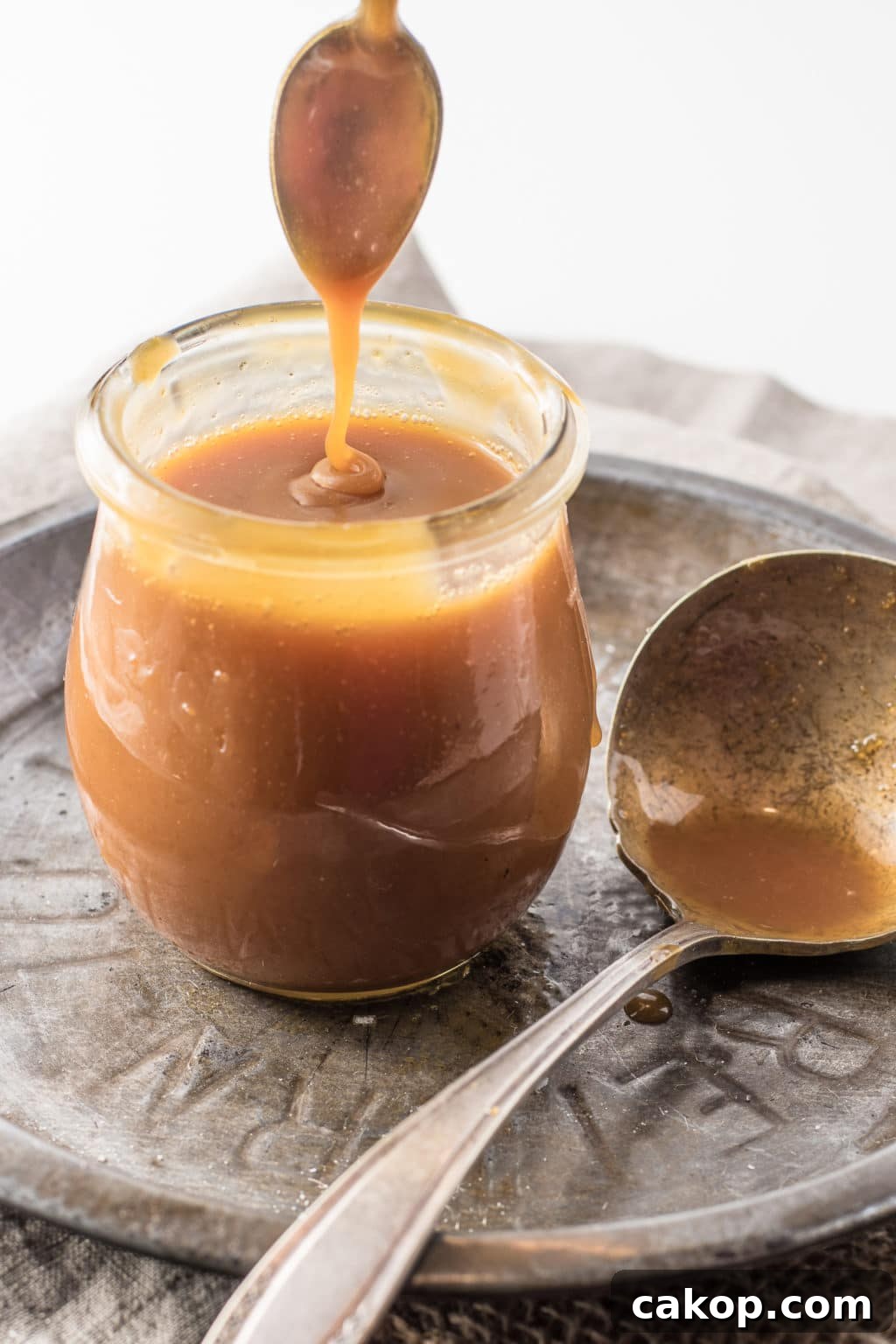 Keto caramel being drizzled into a jar.