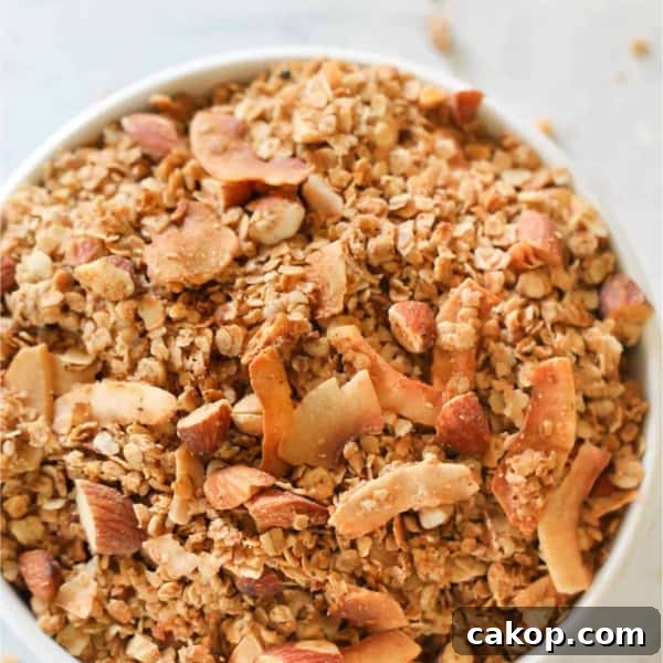 A large white bowl sitting on a counter filled to the top with Almond Butter Granola.