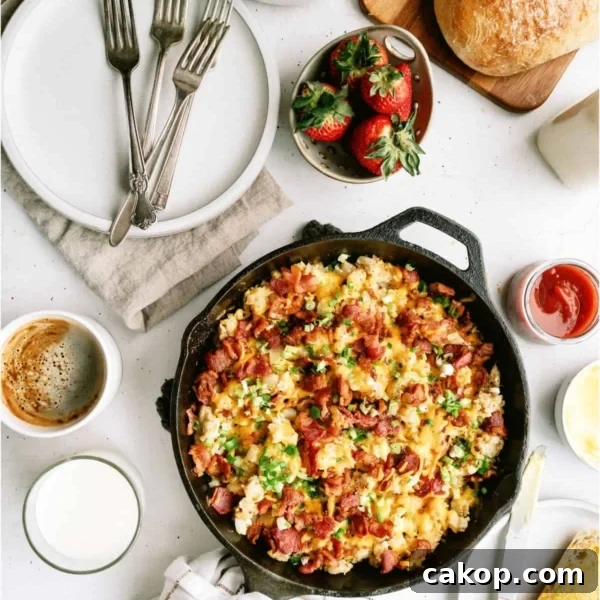 Plate of cheesy scrambled eggs with bacon and green onions, served with a slice of buttered toast. A fork is placed beside the food.