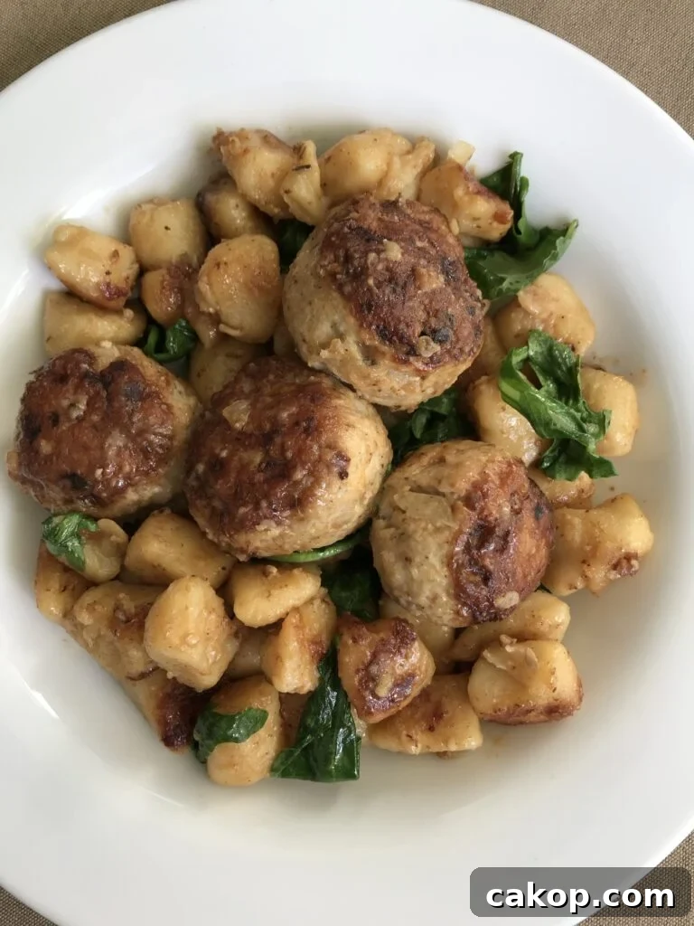 One-Pan Italian Meatball Skillet with Tomato Sauce and Pasta 2 Meatballs with gnocchi and greens in a bowl