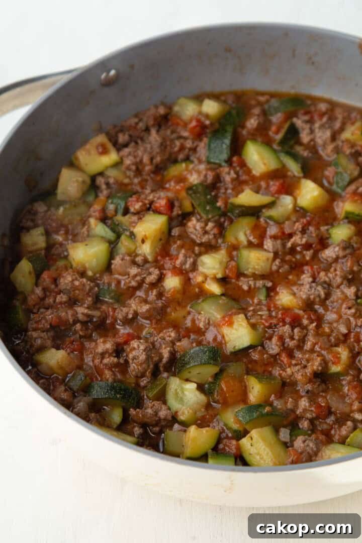 ground beef and zucchini in a tomato mixture in a skillet.