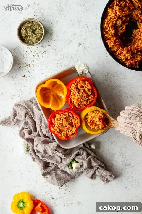 Someone filling peppers with a tomato rice filling