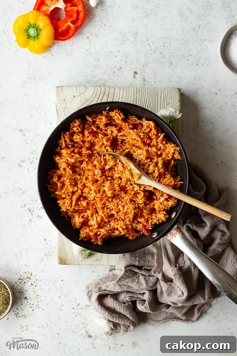 Rice stuffed peppers filling in a pan with a wooden spoon