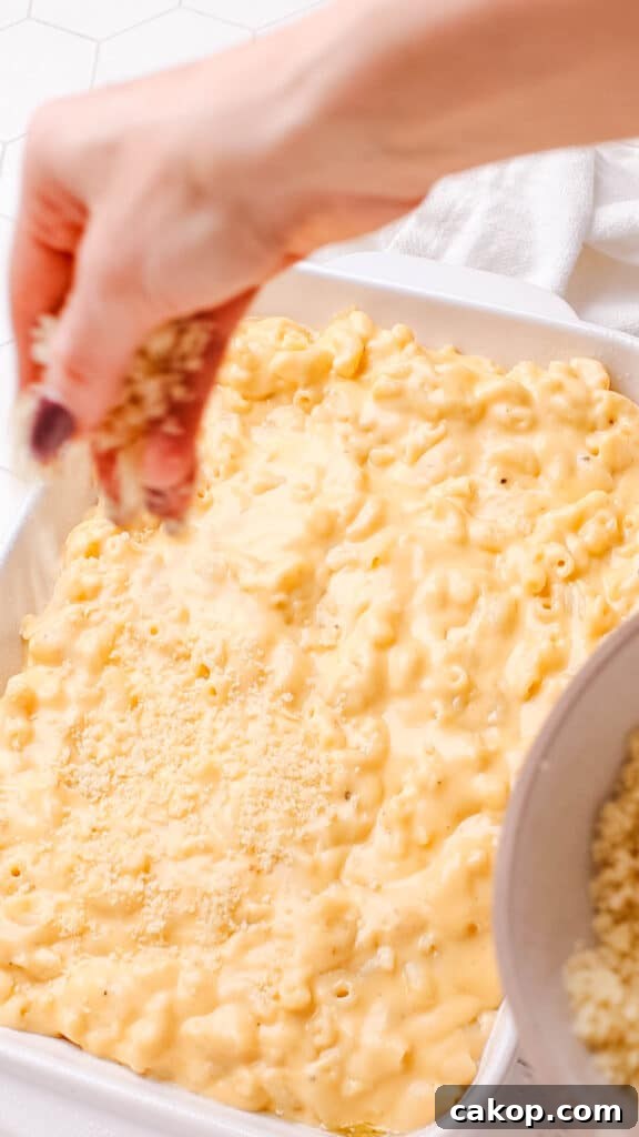 Adding bread crumbs on baked macaroni and cheese.