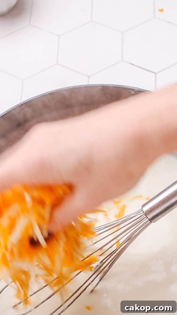 Adding cheddar cheese to sauce for macaroni and cheese.