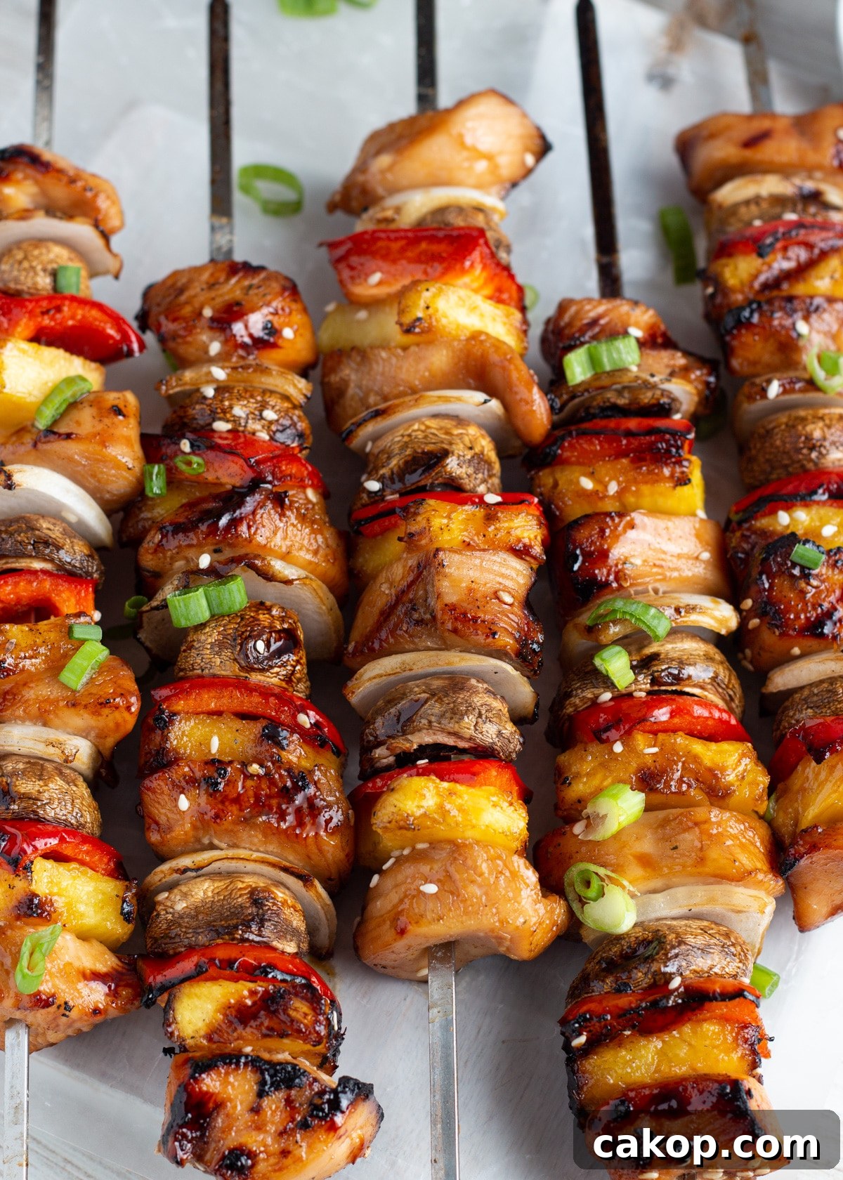 Grilled Teriyaki Chicken and Pineapple Kabobs Recipe 3 Close-up picture of cooked skewers with chicken, pineapple, mushrooms, onion and peppers.