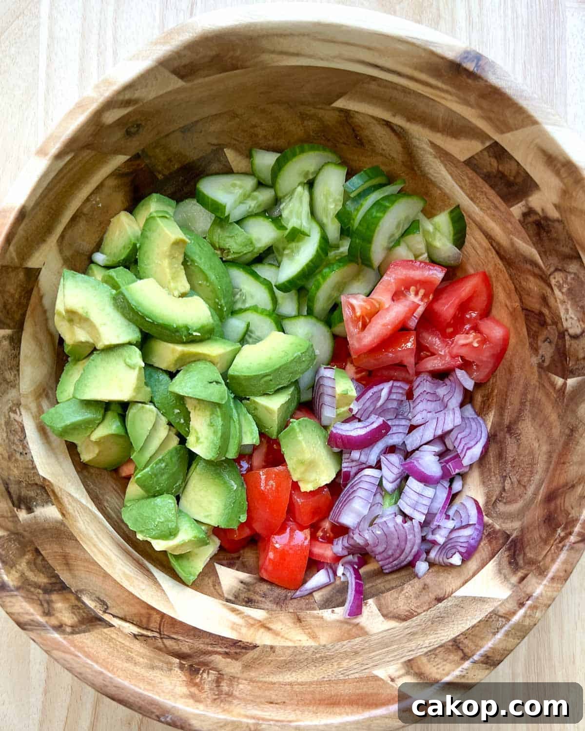 Creamy Avocado and Tomato Salad with Lime and Basil 5 all veggies placed in a large wooden bowl.