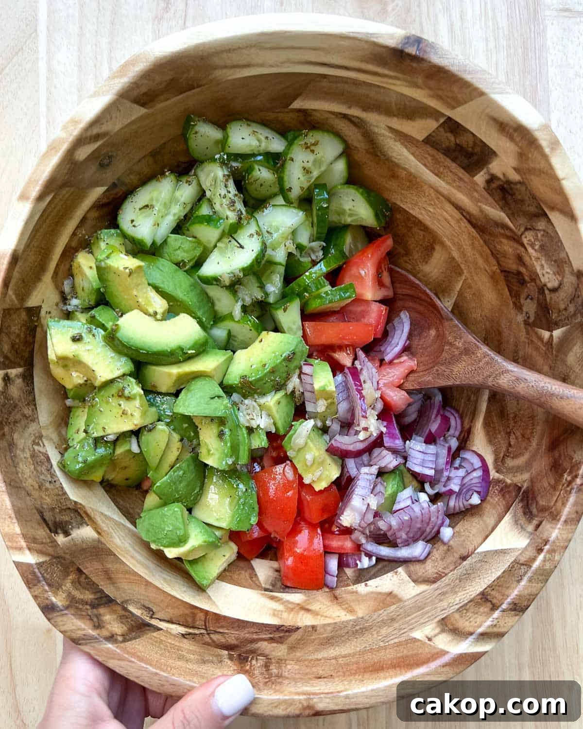 Creamy Avocado and Tomato Salad with Lime and Basil 8 Wooden spoon in salad bowl before mixing.