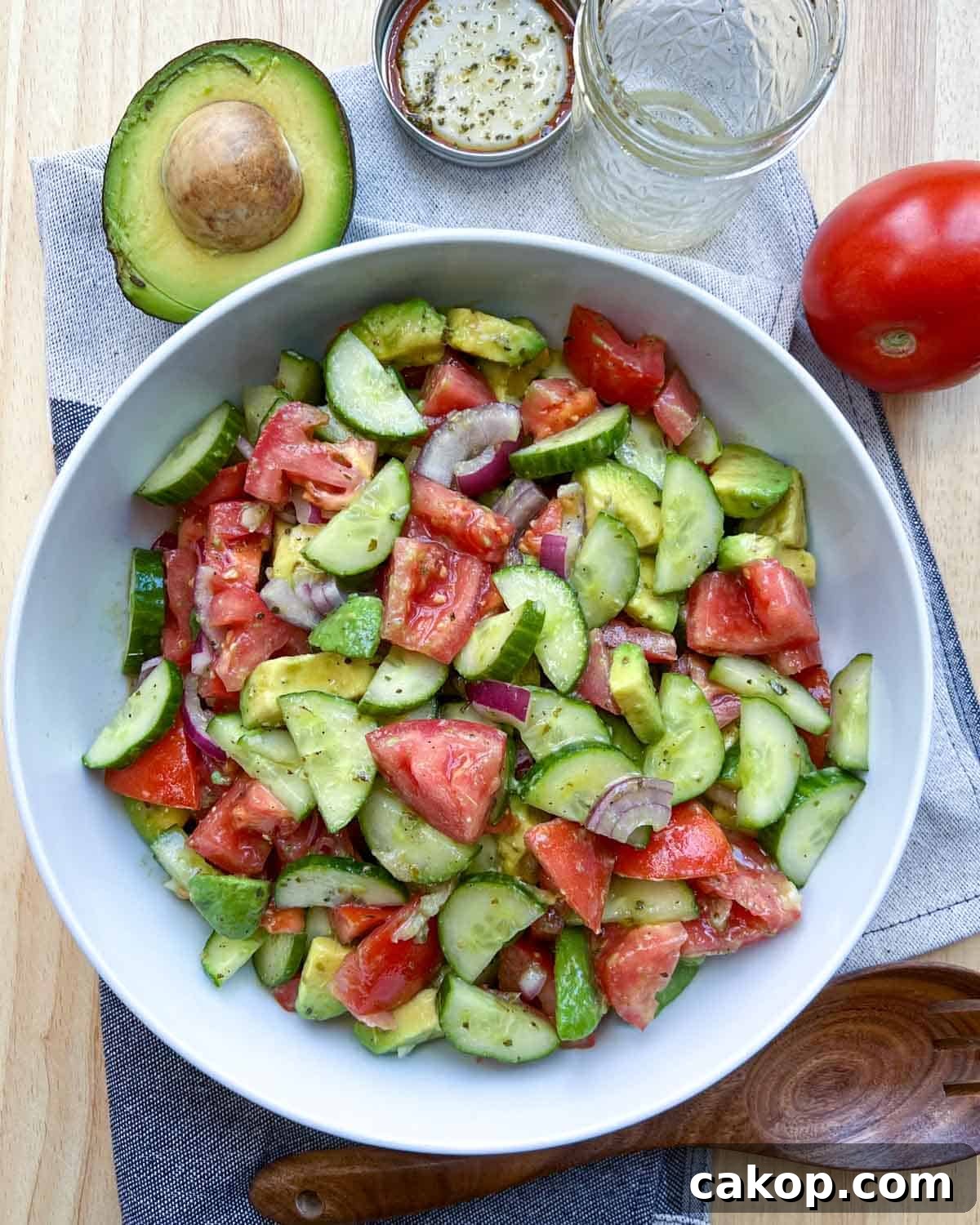 Creamy Avocado and Tomato Salad with Lime and Basil 10 tomato and avocado salad with cucumber in a white dish.