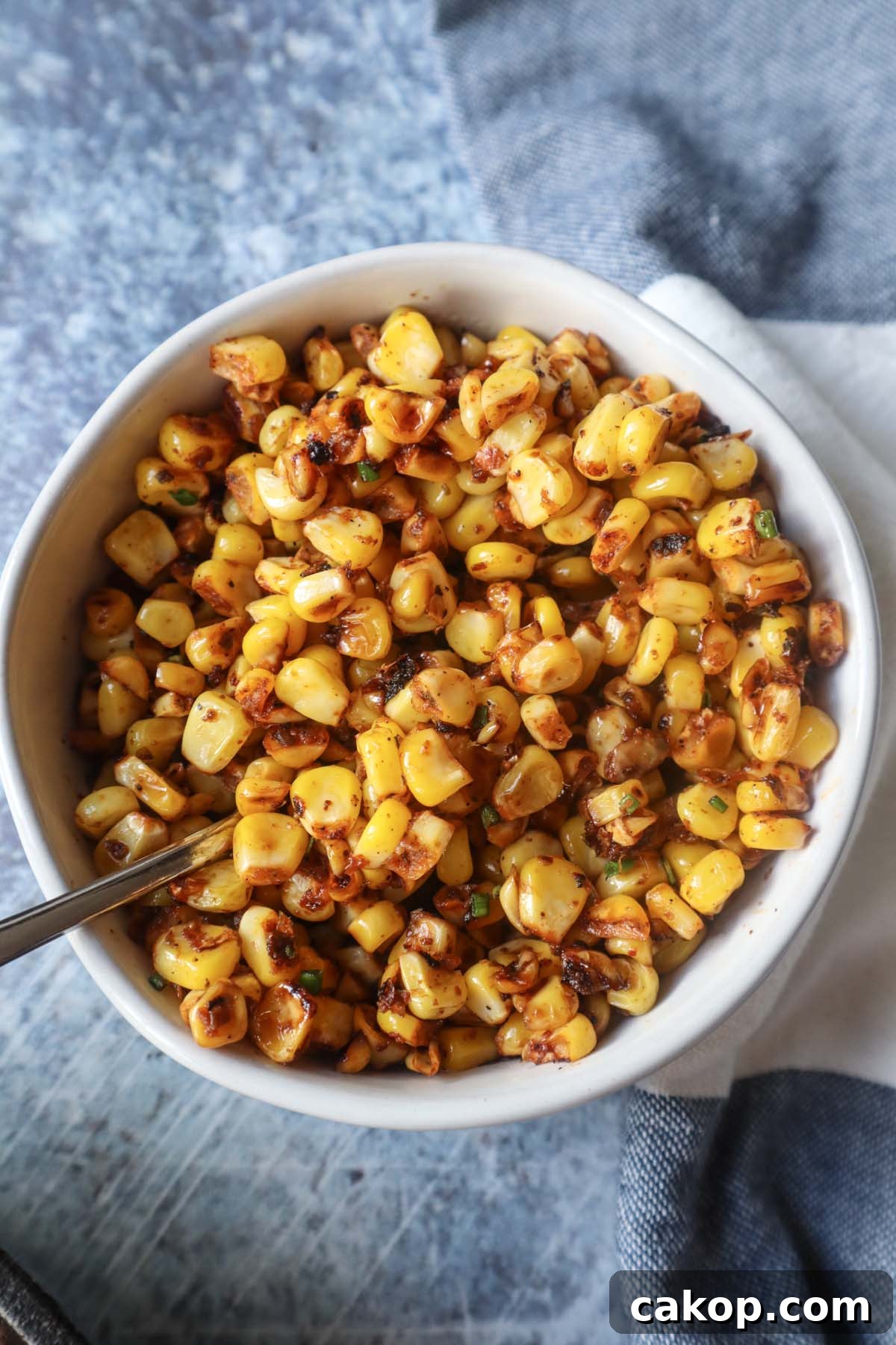 white bowl with blackened corn and chives 