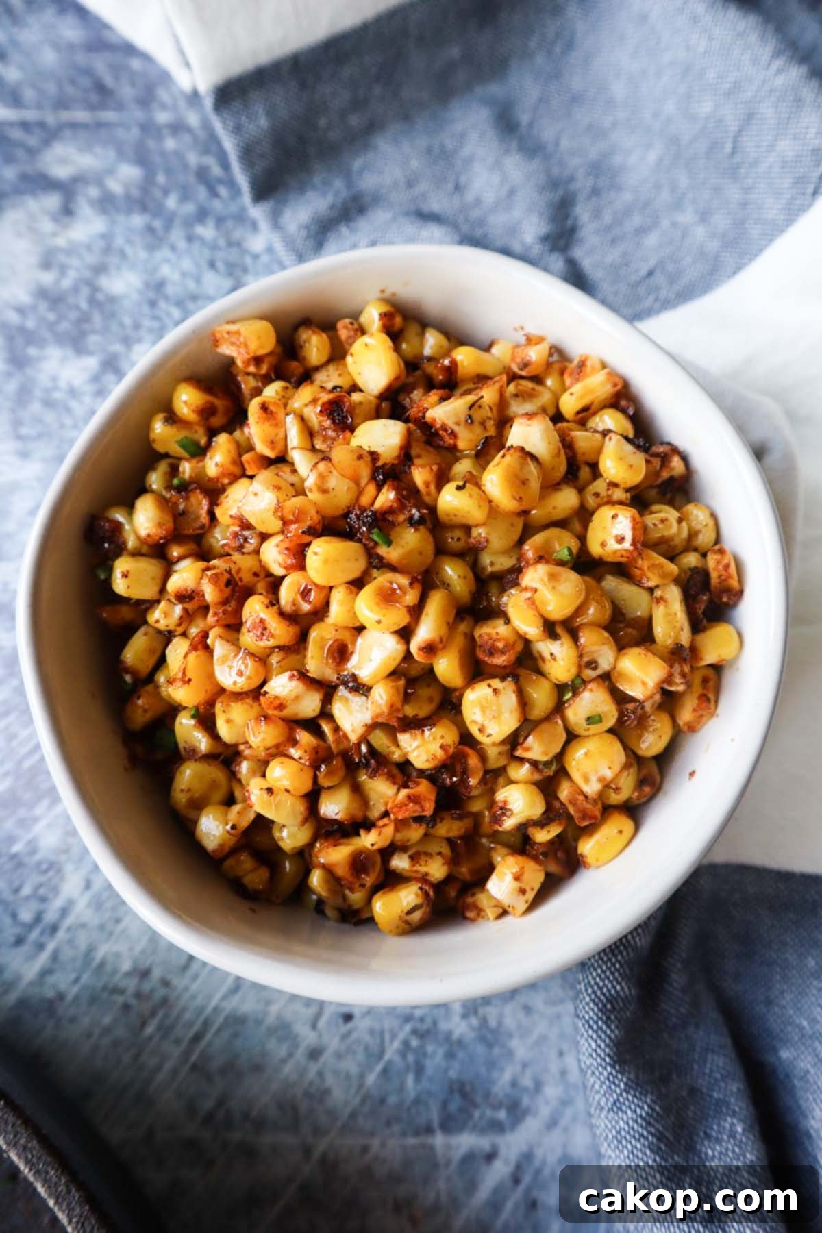 white bowl with blackened corn and chives 