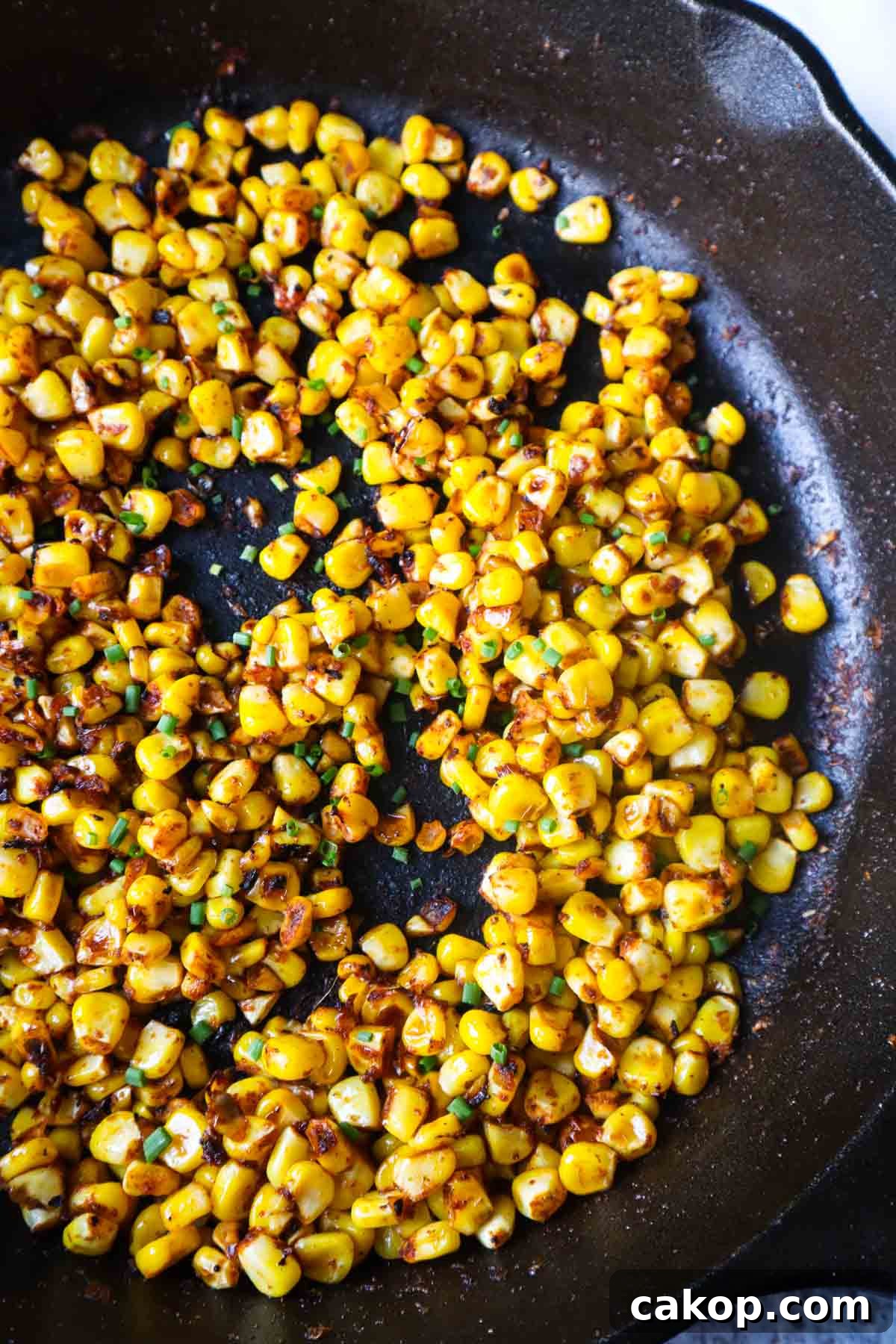 cast iron skillet with blackened corn and chives 