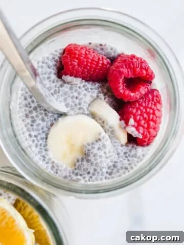 A jar filled with chia pudding and topped with fresh raspberries and bananas.