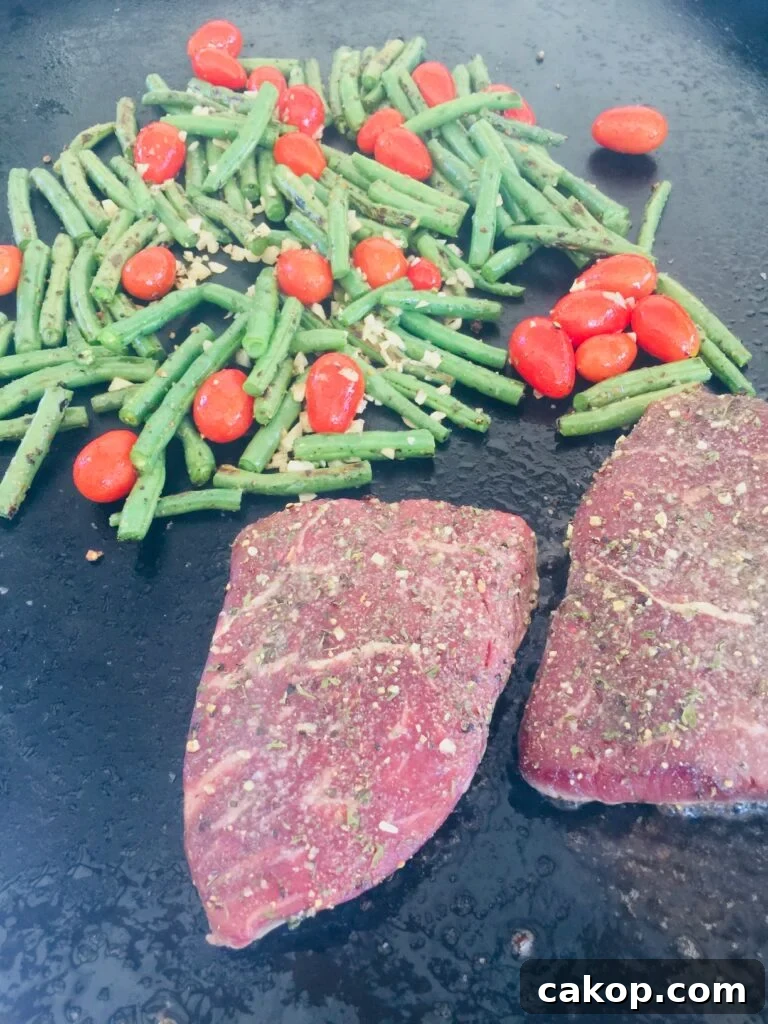 Blackstone Ribeye with Sautéed Garlic Green Beans 8 Blackstone Steak and Green Beans before flipping