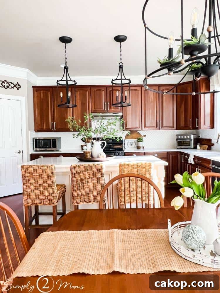 Kitchen with cherry cabinets, white backsplash, painted island, white counters, and black light fixtures.