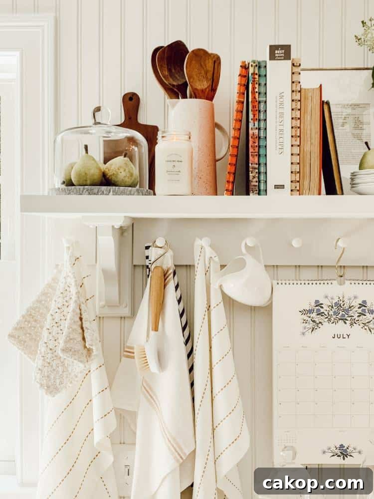 white kitchen shelf styled with wood utensils cookbooks and other essentials