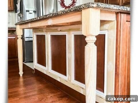 Updating an island in a kitchen with cherry cabinets with table legs and trim.