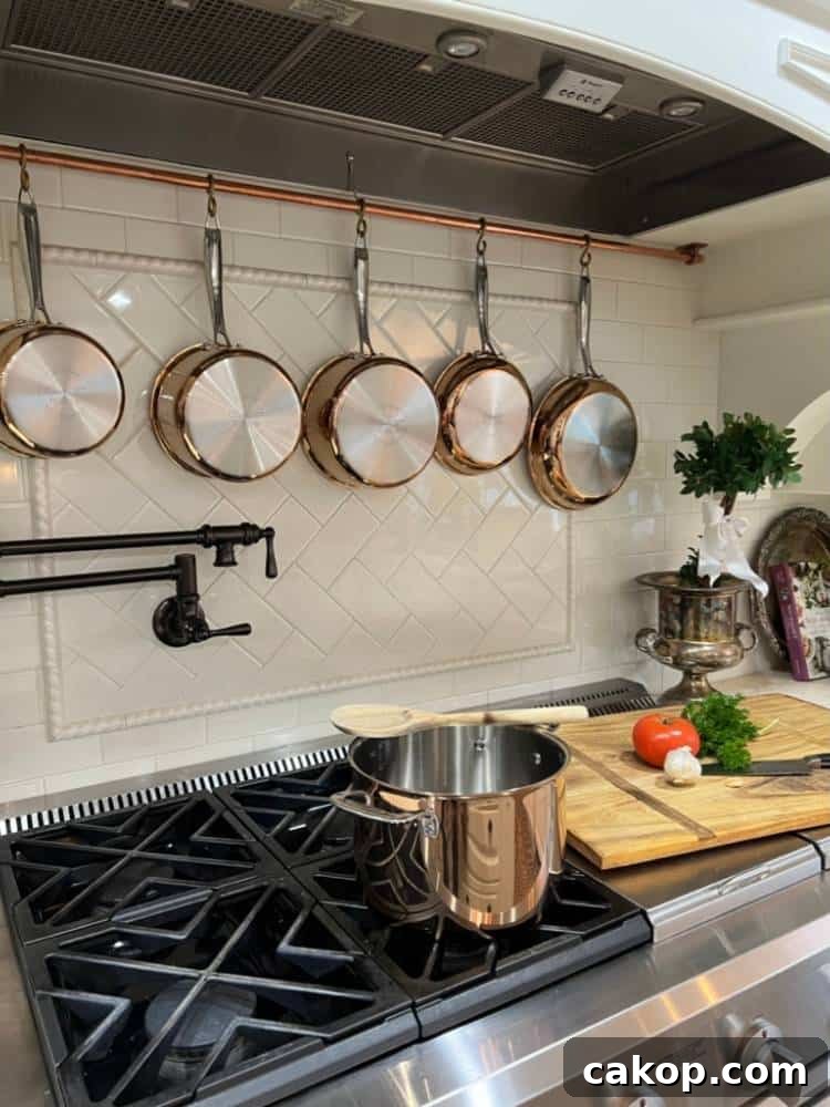 copper pot rack hanging over kitchen range under vent hood