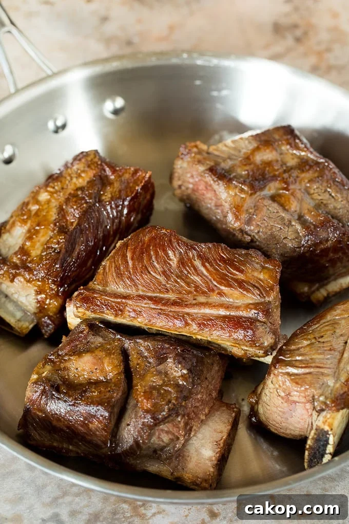 Tender Slow Cooker Short Ribs Recipe for Melt-in-Your-Mouth Beef 4 Seared short ribs in a pan.
