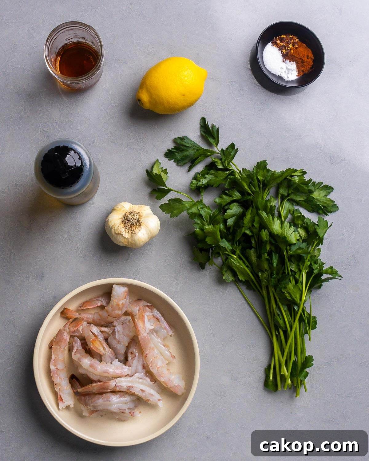 Ingredients shown: sherry, lemon, hot red pepper flakes, paprika, salt, baking soda, olive oil, garlic, parsley, and raw shrimp.